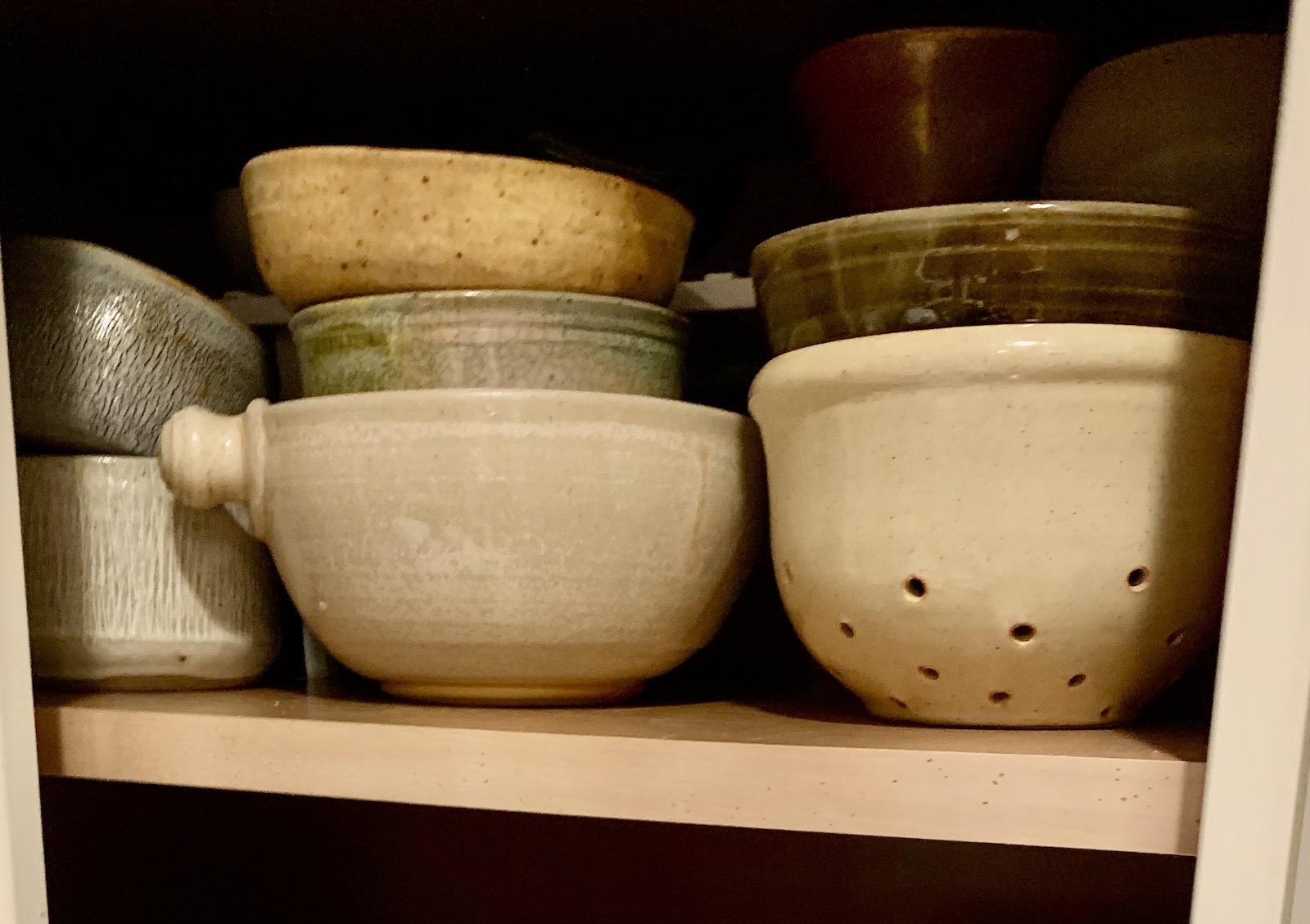 A stock of ceramic bowls in a cupboard